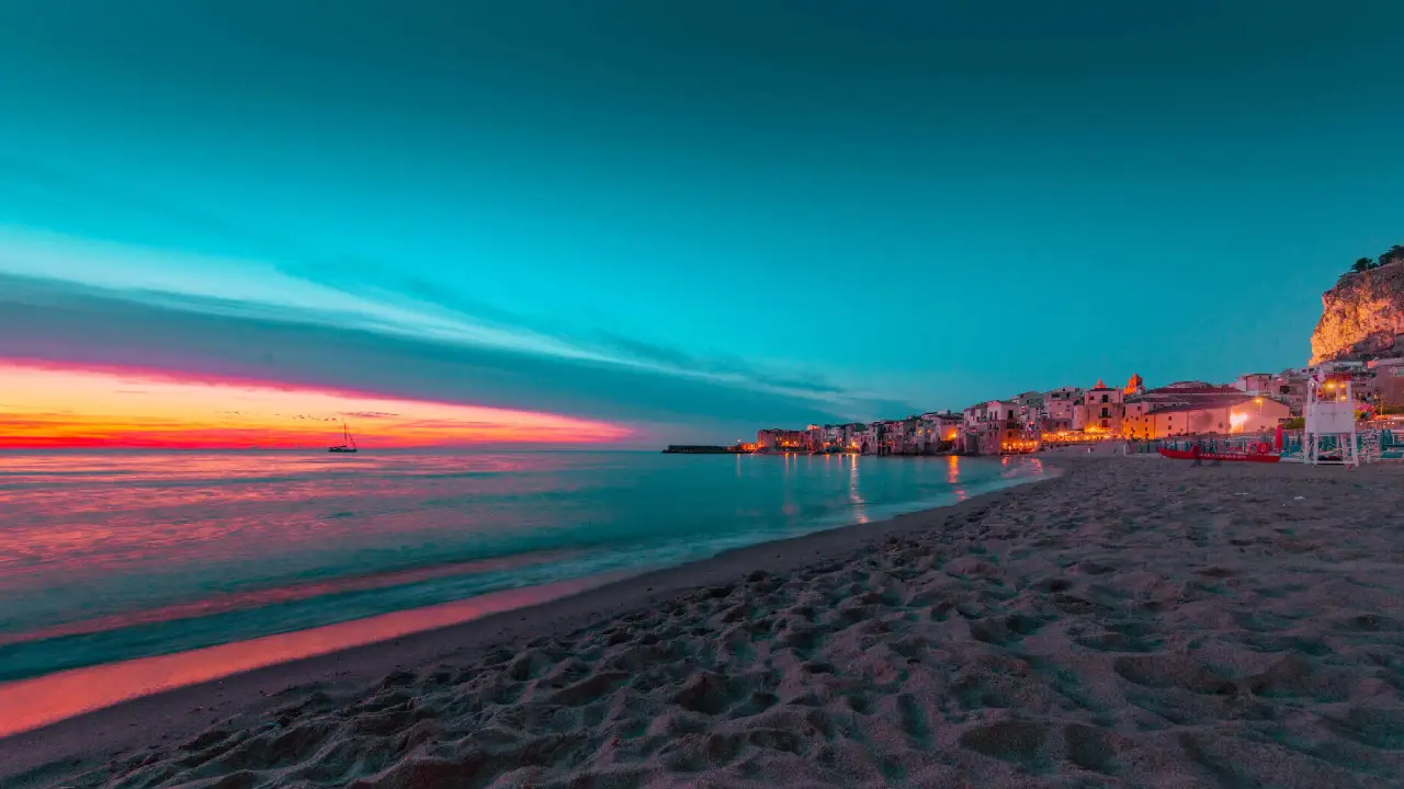 La spiaggia di Cefalù al tramonto con le case sul lungomare