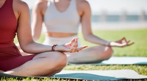 kvinnlig meditation kvinnor som mediterar under semestern i en park nära havet